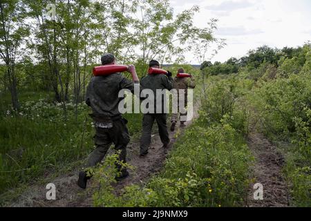 Service members of pro-Russian troops carry leaflet shells at their combat positions in the Luhansk region, Ukraine May 24, 2022. REUTERS/Alexander Ermochenko