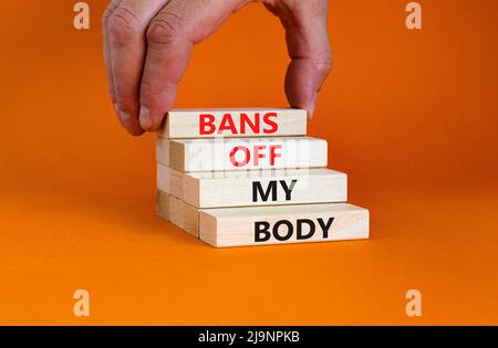 Bans off my body symbol. Concept words Bans off my body on wooden blocks on a beautiful orange table orange background. Women rights concept. Business Stock Photo