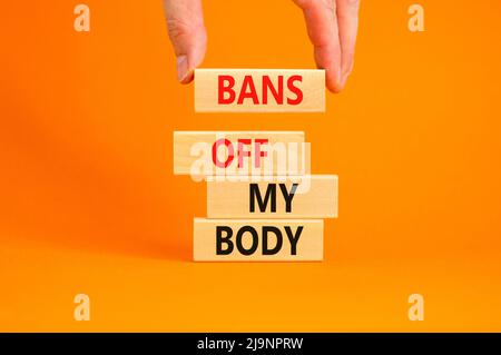 Bans off my body symbol. Concept words Bans off my body on wooden blocks on a beautiful orange table orange background. Women rights concept. Business Stock Photo