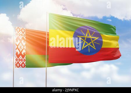 Ethiopia and Belarus flags waving together on blue cloudy sky, two ...