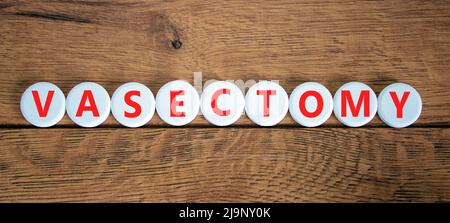 Vasectomy symbol. Concept words Vasectomy on white circles. Beautiful wooden table wooden background. Medical and vasectomy problem concept. Conceptua Stock Photo