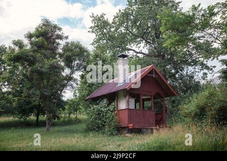 Gazebo for barbecue, pavilion and BBQ Oven in the autumn garden. Place to relax for families in the courtyard of the house. Orchard, apple tree. Stock Photo