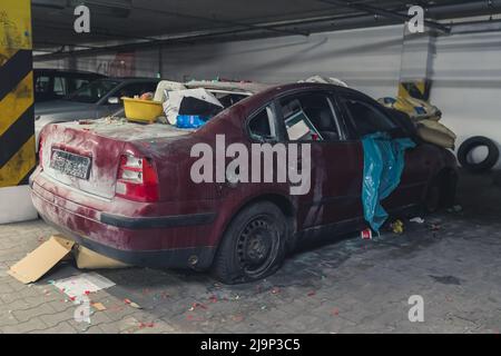 damaged car full of dust, filthy with broken screens and flat tire used as a dump. High quality photo Stock Photo