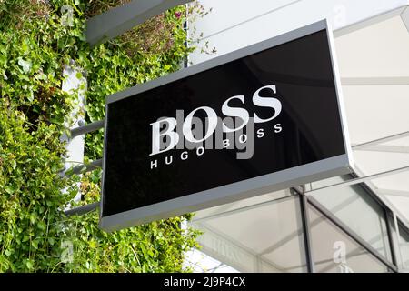 Close up of Hugo Boss retail fashion shop sign logo at Ashford Outlet Center, Kent, England, UK. Stock Photo