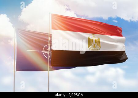 Sunny blue sky and flags of egypt and nato Stock Photo
