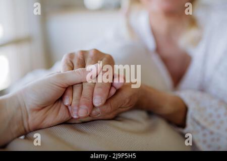 Close up caring grown up daughter holds mother hand provides psychological support Stock Photo