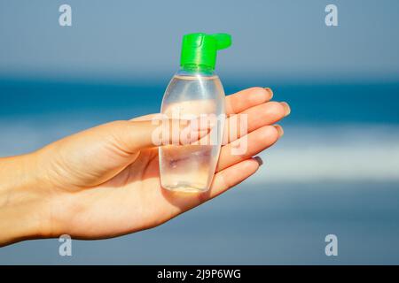 antiseptic in the hands of a woman on the beach Stock Photo