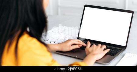 Mock-up concept for advertising, presentation. Laptop with white blank screen stand on a desk, female hands typing on the keyboard, browsing internet, information. Wireless technology concept Stock Photo