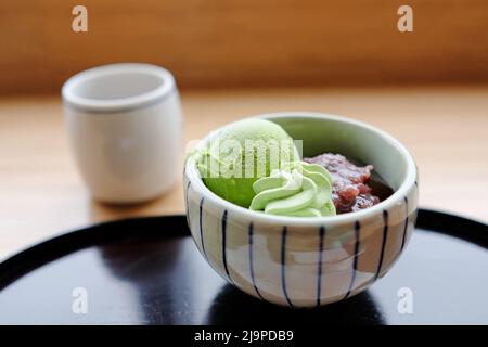 A bowl of matcha ice-cream, green tea mousse and adzuki (red bean) paste and a cup of matcha at Saryo Tsujiri Daimaru - Tokyo Station, Japan Stock Photo