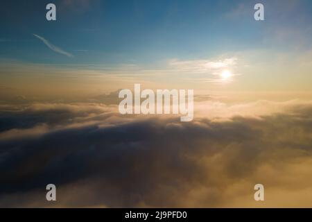 Aerial view from airplane window at high altitude of dense puffy cumulus clouds forming before rainstorm in evening. Stock Photo