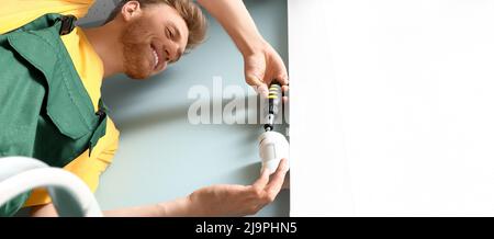 Technician installing smart home security system in room Stock Photo