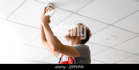 Technician installing smart home security system in room Stock Photo