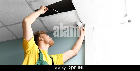 Technician installing smart home security system in room Stock Photo