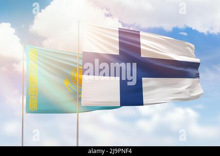 Sunny blue sky and flags of finland and kazakhstan Stock Photo