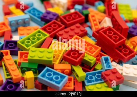 Close up of colorful plastic building block on blue background, school and education concept, high angle view, blue background Stock Photo