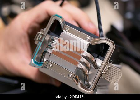 PC CPU air cooling system. Aluminum heat sink in hand of technicians man. Selective focus Stock Photo