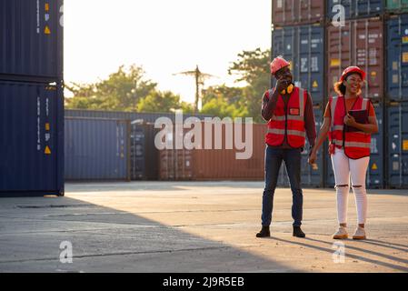 Two African american male and female worker smiling with confidence and success at workplace of industrial container warehouse. Stock Photo