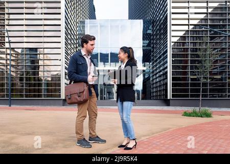 coworkers talking in front of an office building Stock Photo