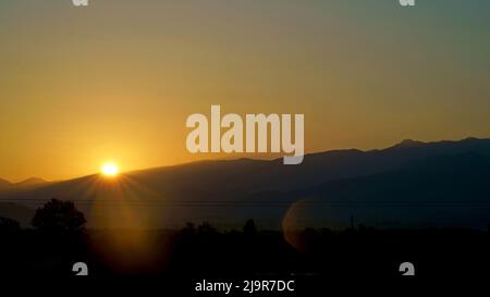 Sunrise over the city of Cabuletti. Georgia. Early morning. The sun rises over mountains and rooftops Stock Photo