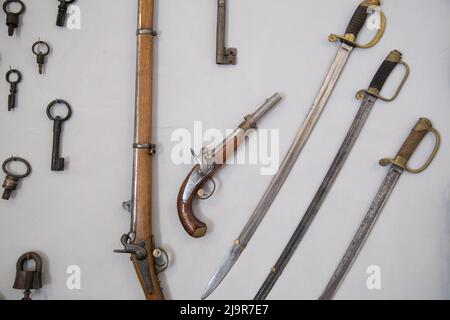 Retro pistols with sabre on wall. Stock Photo