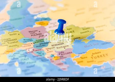 Blue push pin pointing at Romania on a political world map Stock Photo