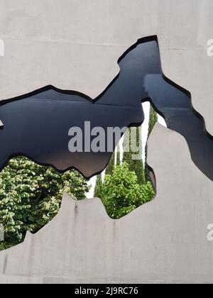 Wall with a hole where you can see trees. Concept, nature, green. Stock Photo