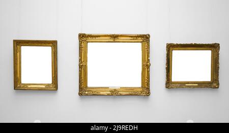 Three gold empty frame on white wall. Stock Photo