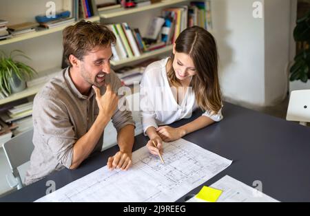 Group of business people on meeting with construction engineer architect looking blueprint plans Stock Photo