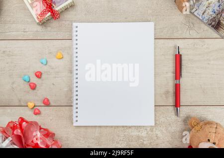 Notepad, pen candy and teddybear on wooden table. Stock Photo