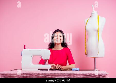 sewing pattern,sewing machine and maniken in studio pink background.seamstress curve template. tailor creates a collection outfits sews clothes in Stock Photo