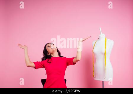 sewing pattern,sewing machine and maniken in studio pink background.seamstress curve template. tailor creates a collection outfits sews clothes in Stock Photo