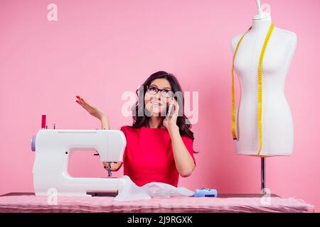 sewing pattern,sewing machine and maniken in studio pink background.seamstress curve template. tailor creates a collection outfits sews clothes in Stock Photo