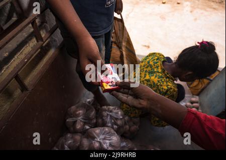May 24, 2022, Tehatta, West Bengal, India: The West Bengal government has directed state government schools to distribute Mid Day Meal supplies to parents of students during the summer vacation so that the needy children are not deprived of the scheme. The notice said that each student would get 2 kg of rice, 2 kg of potato, 250 grams of sugar, 250 grams of pulses, and one bar of soap. So the students came to a primary school to get their food items during summer vacation and some of them are also helping to give food items at Nabin Nagar, West Bengal. (Credit Image: © Soumrabyata Roy/Pacific Stock Photo