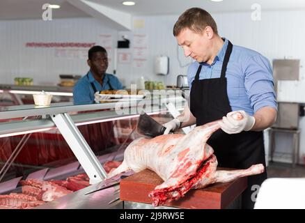 Butcher processing carcase of lamb Stock Photo - Alamy