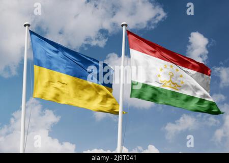 Ukraine and Tajikistan two flags on flagpoles and blue cloudy sky background Stock Photo