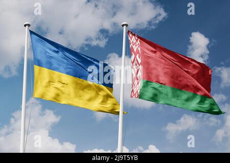 Ukraine and Belarus two flags on flagpoles and blue cloudy sky background Stock Photo