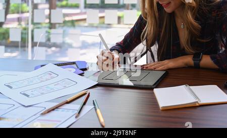 Creative woman sketch planning application process development prototype wireframe for web mobile phone. Stock Photo