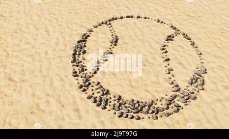 Concept conceptual stones on beach sand handmade symbol shape, golden sandy background, ball sign. A 3d illustration metaphor for sport,  basketball Stock Photo