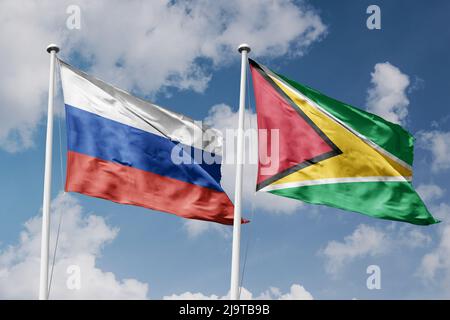 Russia and Guyana two flags on flagpoles and blue cloudy sky background Stock Photo