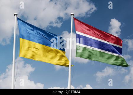 Ukraine and Gambia two flags on flagpoles and blue cloudy sky background Stock Photo