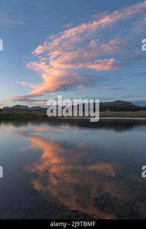 Clouds illuminated by setting sun at Dream Lake. Bridger Wilderness, Wind River Range, Wyoming. Stock Photo