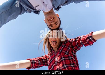 Cute couple posing while making faces from below Stock Photo