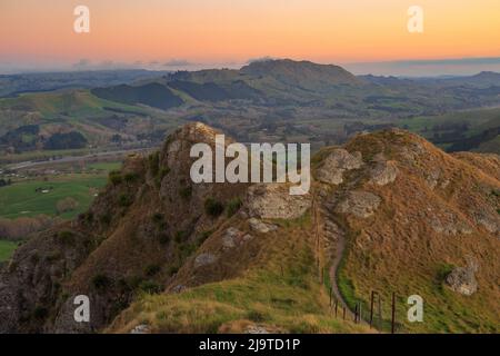 View from the summit of Te Mata Peak, a mountain in the Hawke's Bay region of New Zealand, at sunset, looking down at the Tukituki River Stock Photo