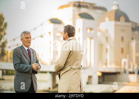 Two amazing senior businessmen are talking by the river, close up Stock Photo