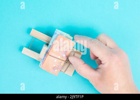 Euro banknotes in a mousetrap, bank loan, finanicial debt, inflation, risky credit and investment, someone wants to take the money, greed Stock Photo