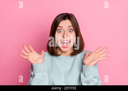 Photo of impressed millennial lady arms up wear blue shirt isolated on pink color background Stock Photo