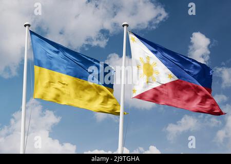 Ukraine and Philippines two flags on flagpoles and blue cloudy sky background Stock Photo