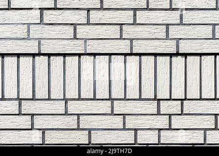 Background made of the facade of the building made white brick, a large fugue between the bricks is visible. Stock Photo