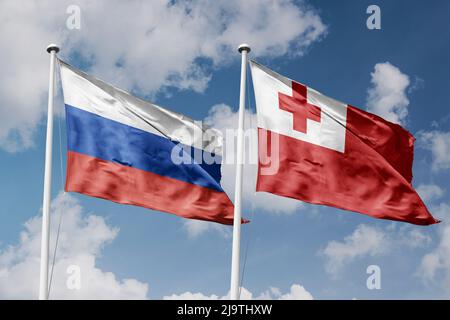 Russia and Tonga two flags on flagpoles and blue cloudy sky background Stock Photo