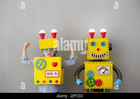 Happy child with robot. Funny kid have an idea. Success, creative and innovation technology concept Stock Photo
